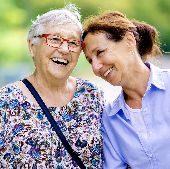 A woman and her elderly mother enjoy time outside together.
