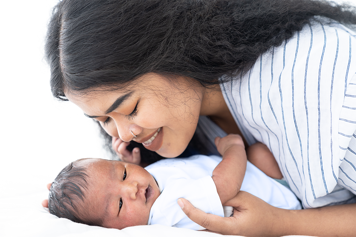 A new mother sweetly cuddles with her newborn baby.