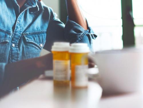 Man with coffee and pill bottles