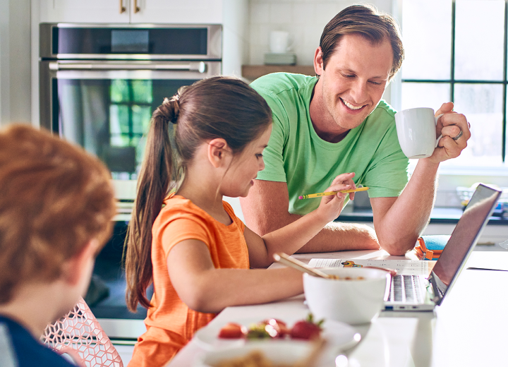 Man enjoys breakfast with his young children.