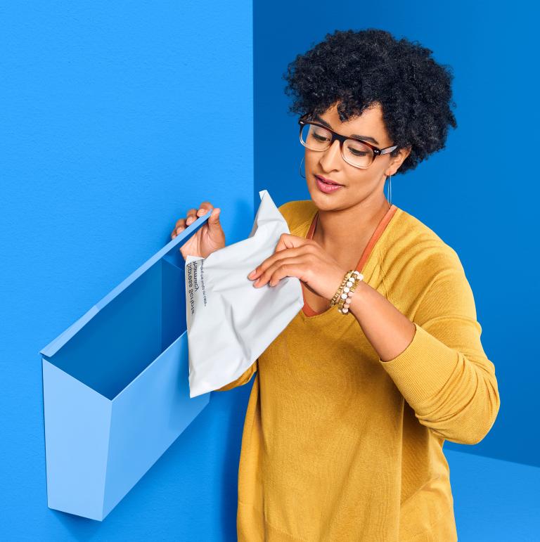 A woman collects mail from her mailbox.