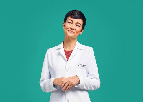 A pharmacist smiles in her Express Scripts® Pharmacy lab coat.